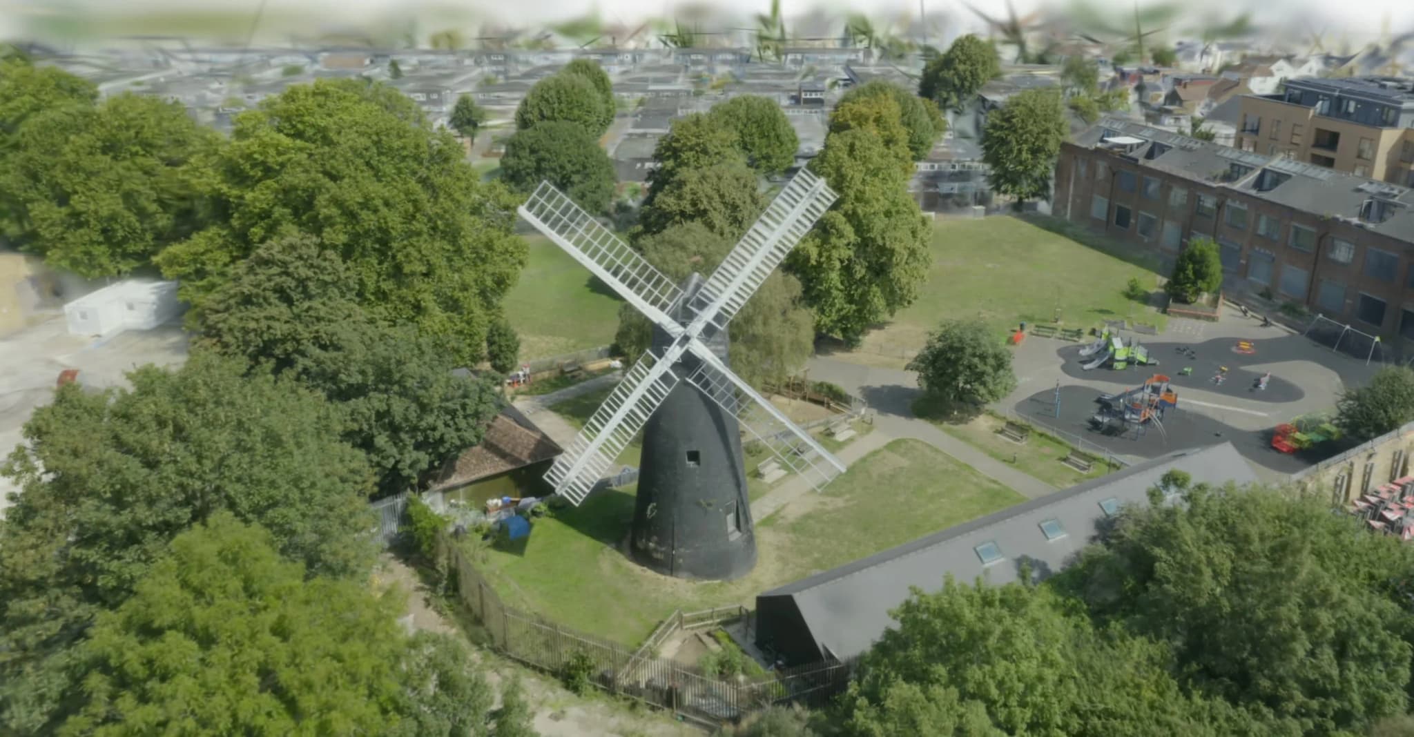 18th-century windmill heritage site aerial view showing traditional English architecture with sails and brick construction in rural countryside landscape